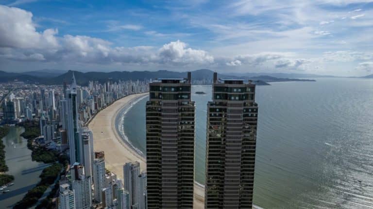 Vista aérea de Balneário Camboriú, Santa Catarina, com as Torres Gêmeas Yachthouse em destaque, a extensa faixa de areia da Praia Central e o mar do Atlântico ao fundo